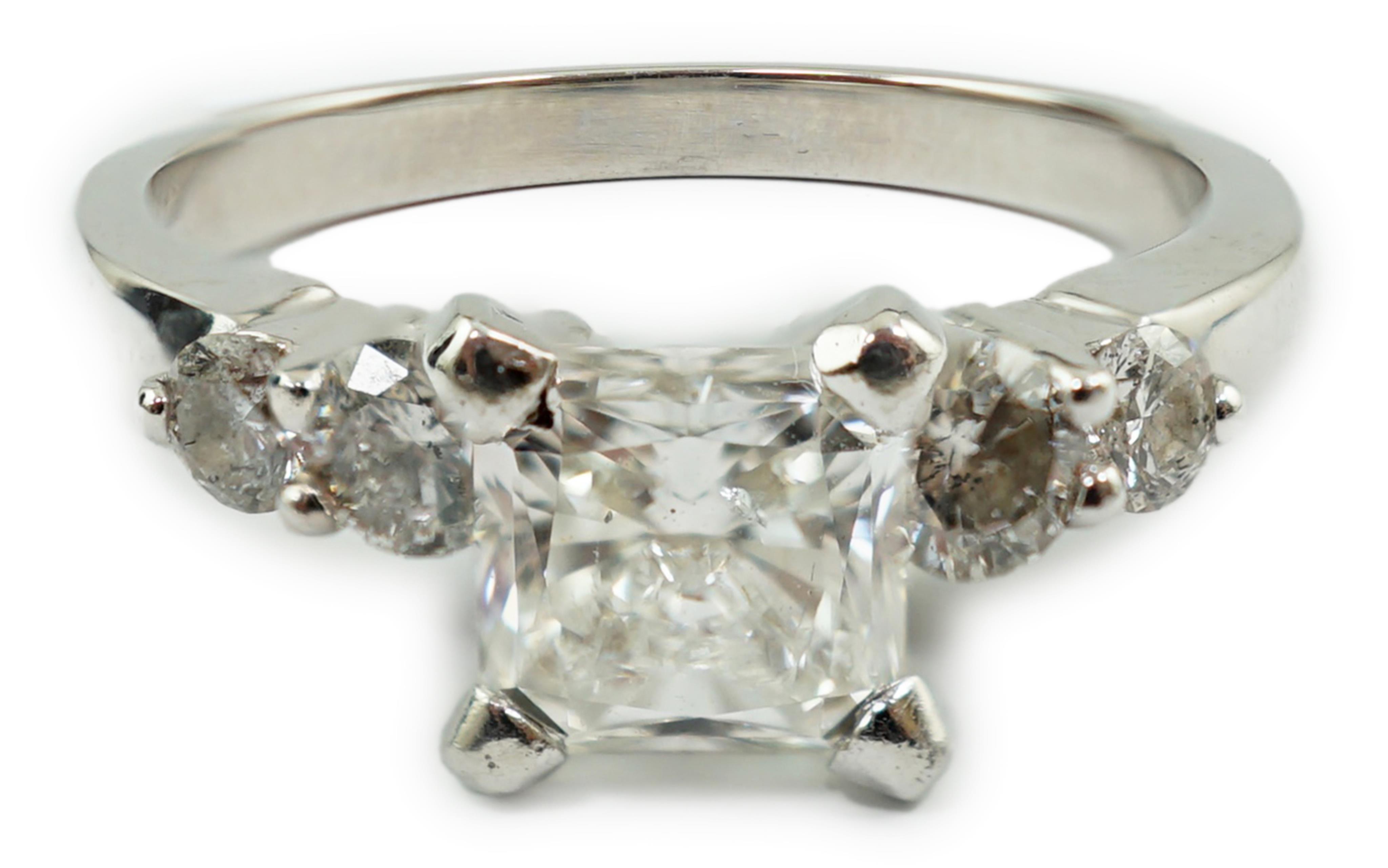 A modern 14k white gold and single stone diamond set ring, with four stone diamond set shoulders